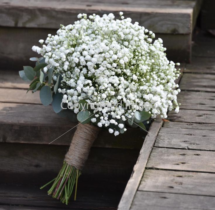 a bouquet of white flowers sitting on some steps