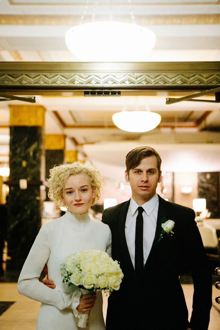 a man and woman in formal wear standing next to each other on the hallway way