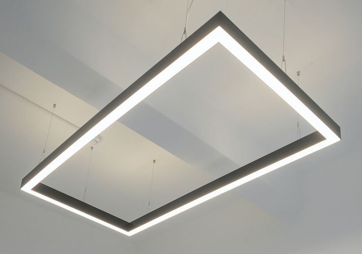 a suspended light fixture in the shape of a triangle with lights hanging from it's sides