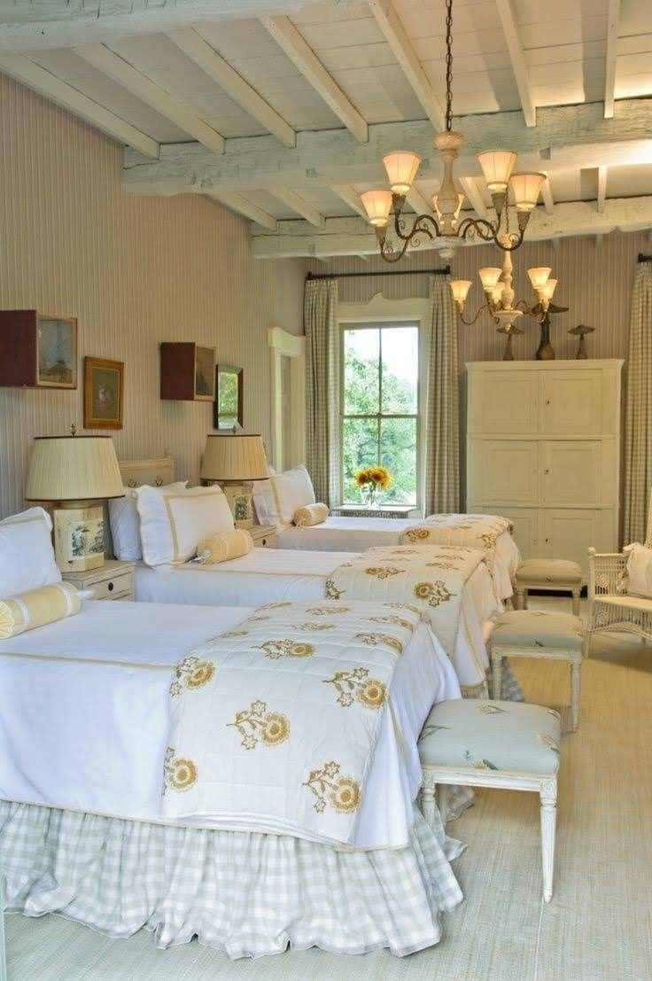 two beds in a room with white walls and ceilinging, one has a chandelier