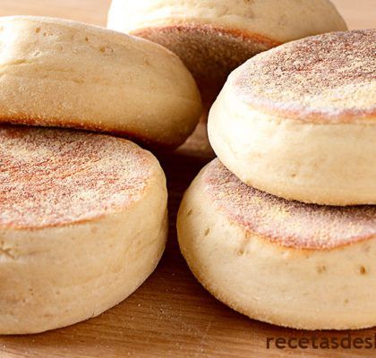 several biscuits stacked on top of each other in the middle of a wooden table with text overlay that reads how to make english muffins