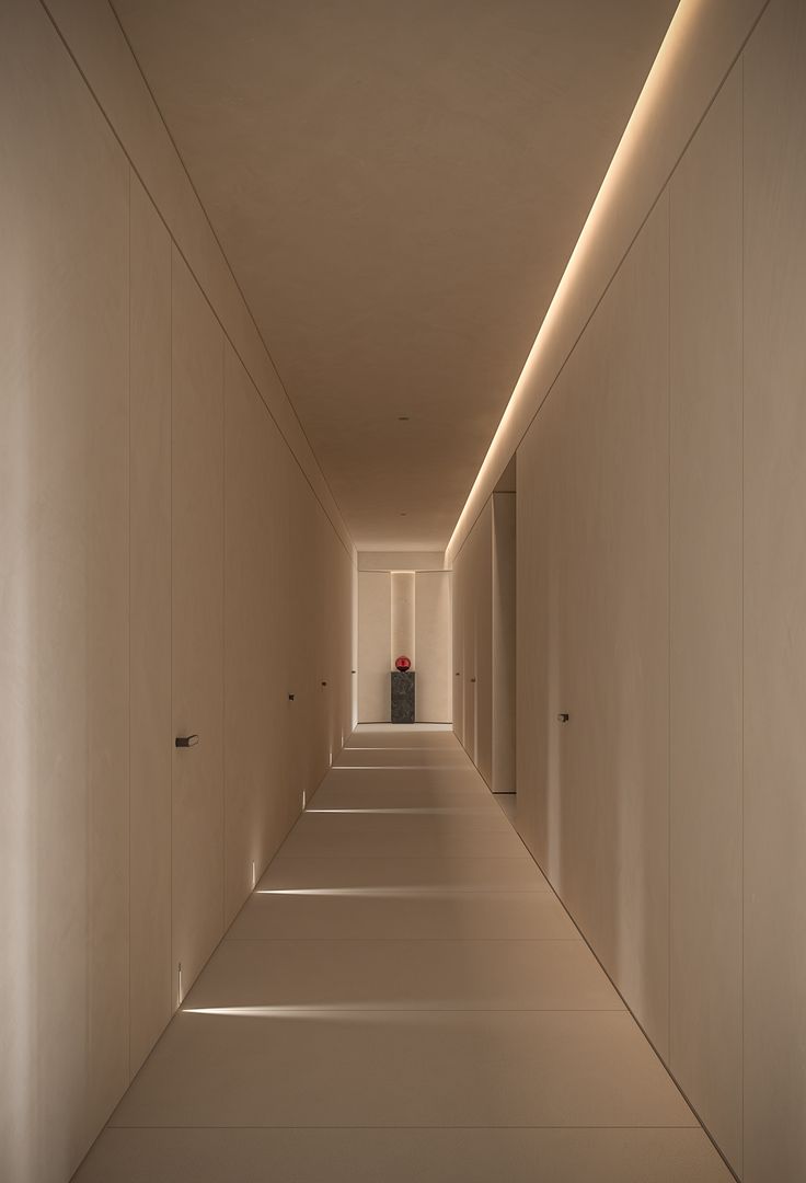 an empty hallway with white walls and lights