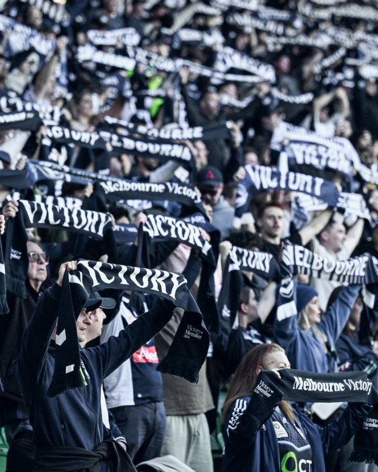 a large group of people holding up signs in the stands at a sporting event,