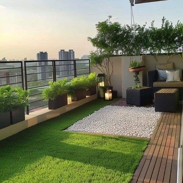 an outdoor patio with grass and potted plants on the roof top deck, overlooking the city