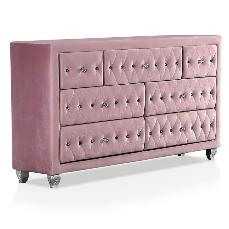 a pink velvet dresser with diamond studding on the top and bottom drawers, in front of a white background