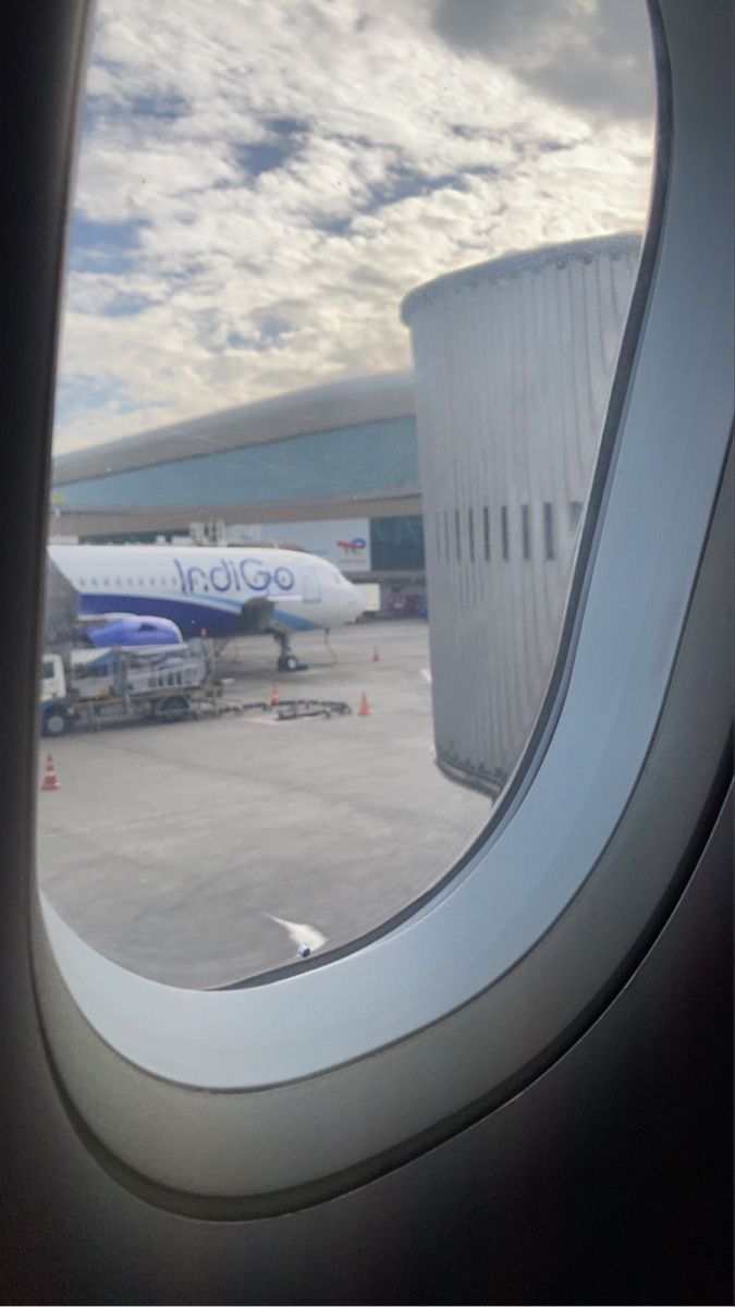 an airplane window looking out at the tarmac