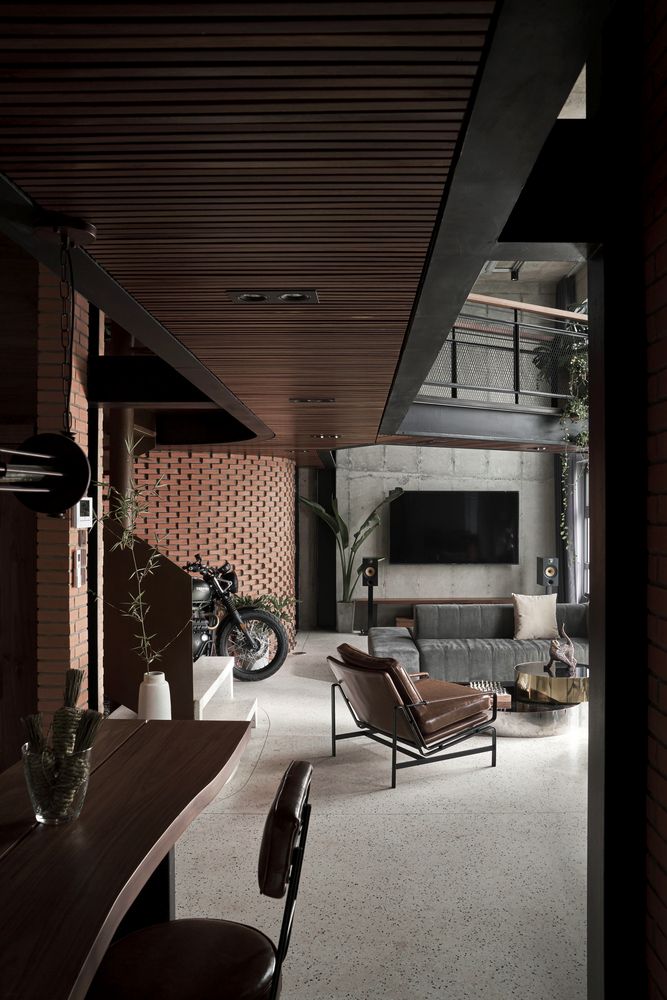 a living room filled with furniture and a motorcycle parked in front of a tv mounted on the wall