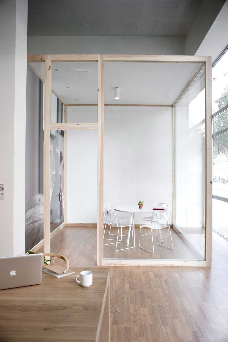 an open room with a laptop on the floor next to a table and chairs in it