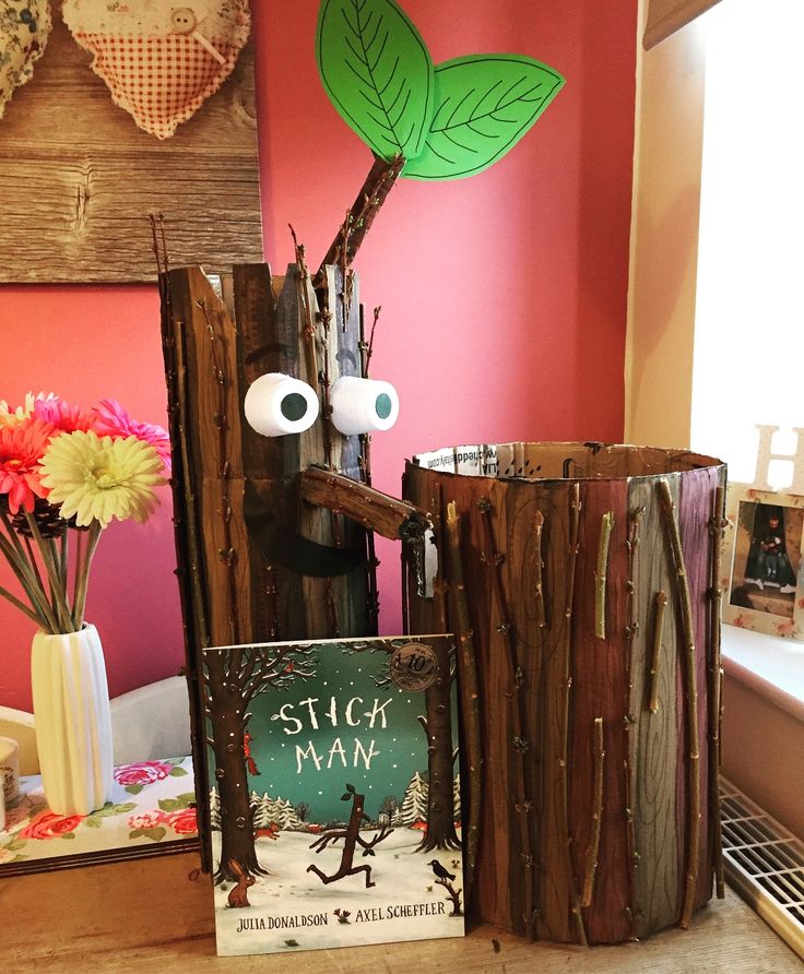 a wooden stump with two eyes and a book in front of it on a table