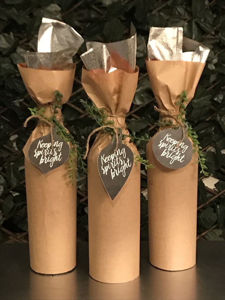 three brown paper wrapped wine bottles with tags on them