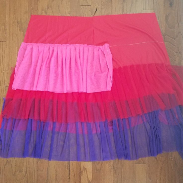 two different colored skirts sitting on top of a wooden floor