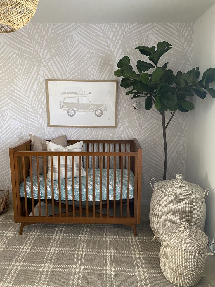 a baby's room with a crib, potted plant and pictures on the wall