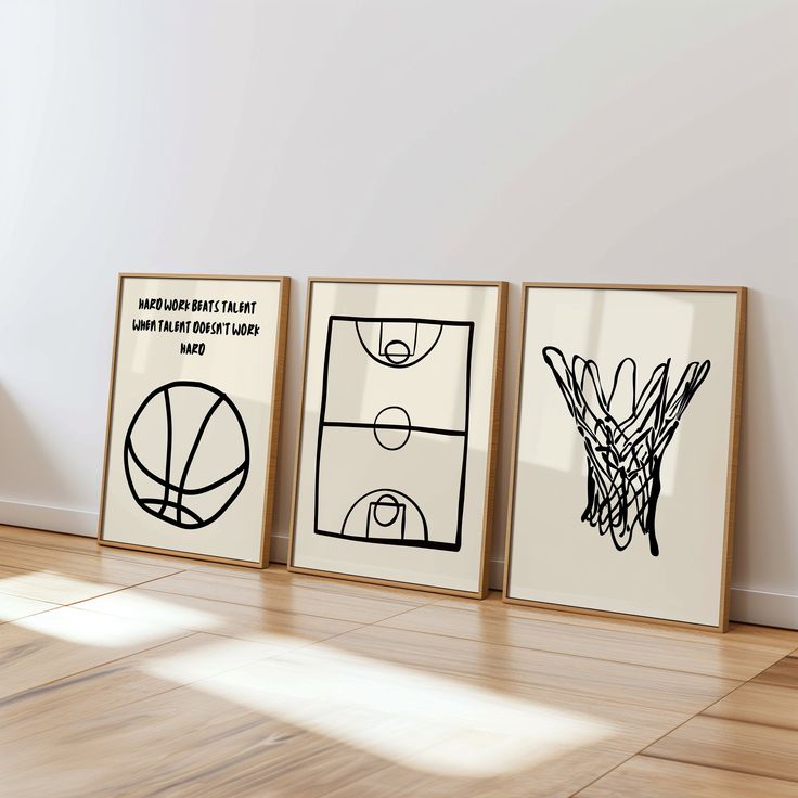 three framed basketball posters on the wall in an empty room with hard wood flooring