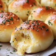 some bread rolls with cheese and herbs on them