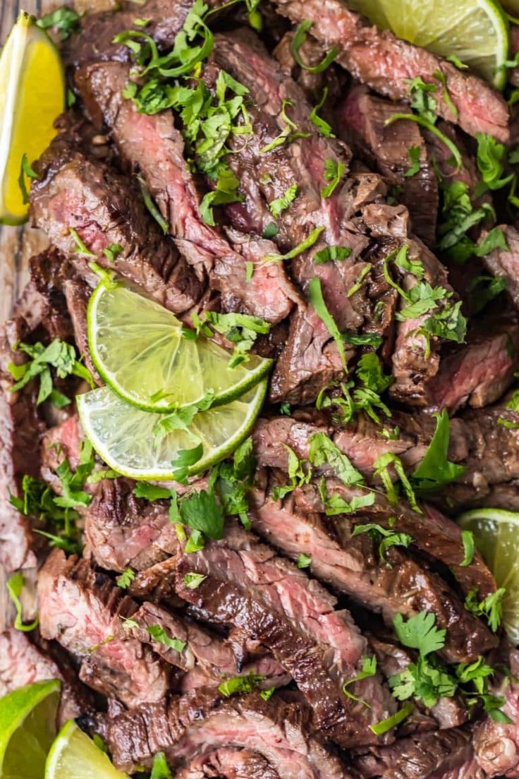 steak with cilantro and limes on a platter, ready to be served