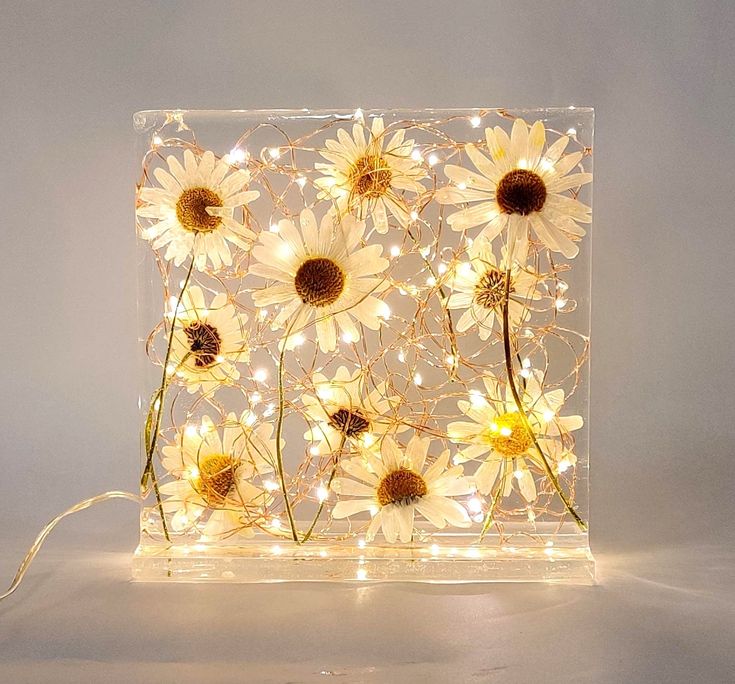 a light that has some flowers on it with lights in front of it and behind it