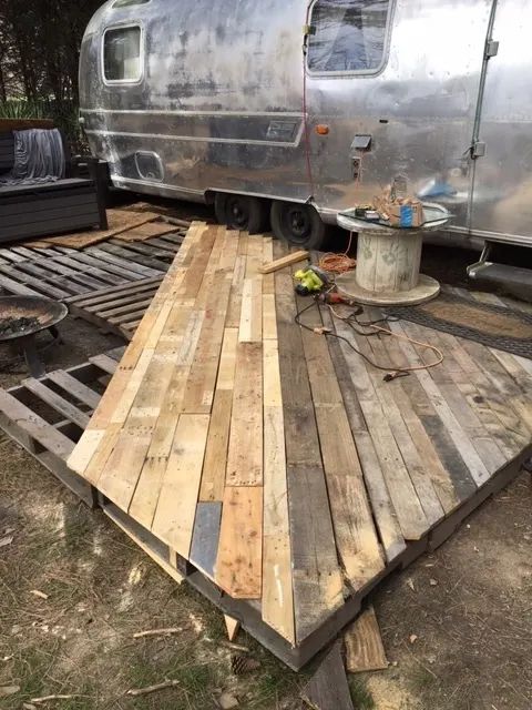 a trailer is parked next to a wooden deck