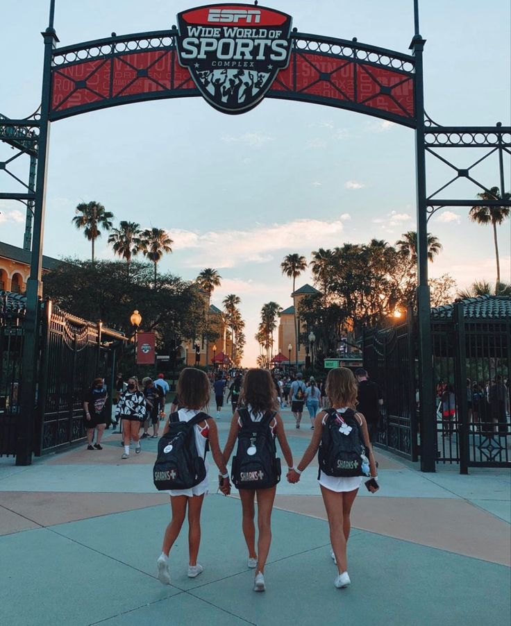 two girls are walking under an arch at the entrance to san francisco's super bowl stadium