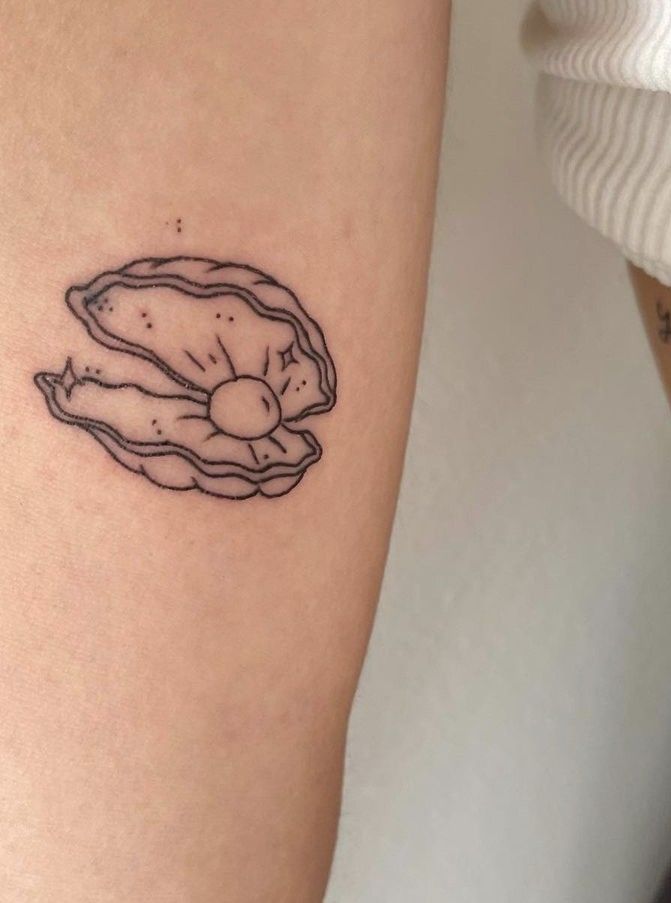 a woman's leg with a tattoo on it that has an image of a shell