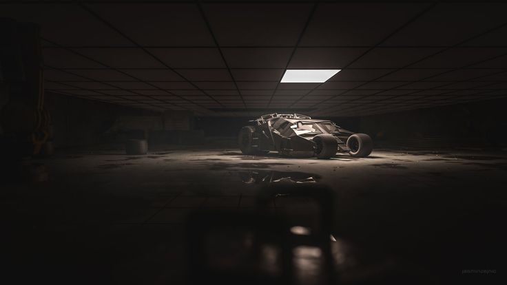 an old race car is parked in a dark garage with its lights on and the door open