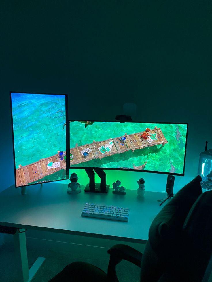 two computer monitors sitting on top of a desk in front of a keyboard and mouse