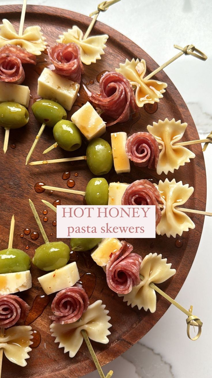 several different types of pasta skewers on a wooden platter with text that reads hot honey pasta skewers