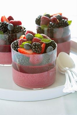 three desserts with berries, raspberries and blueberries in them on a white plate