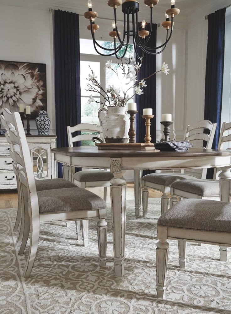 a dining room table with chairs and a chandelier