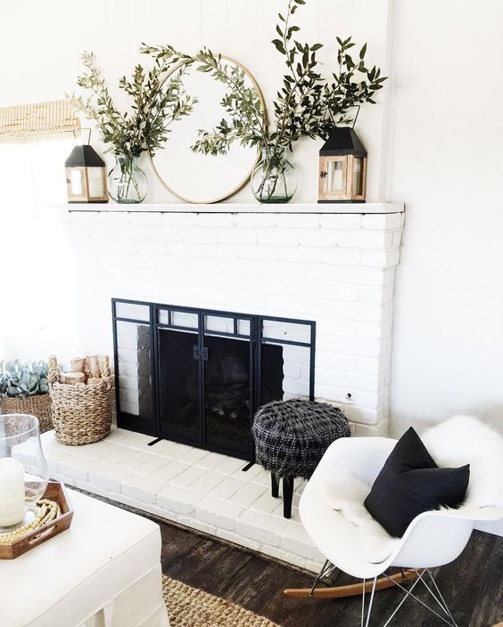 a living room with white furniture and a fireplace