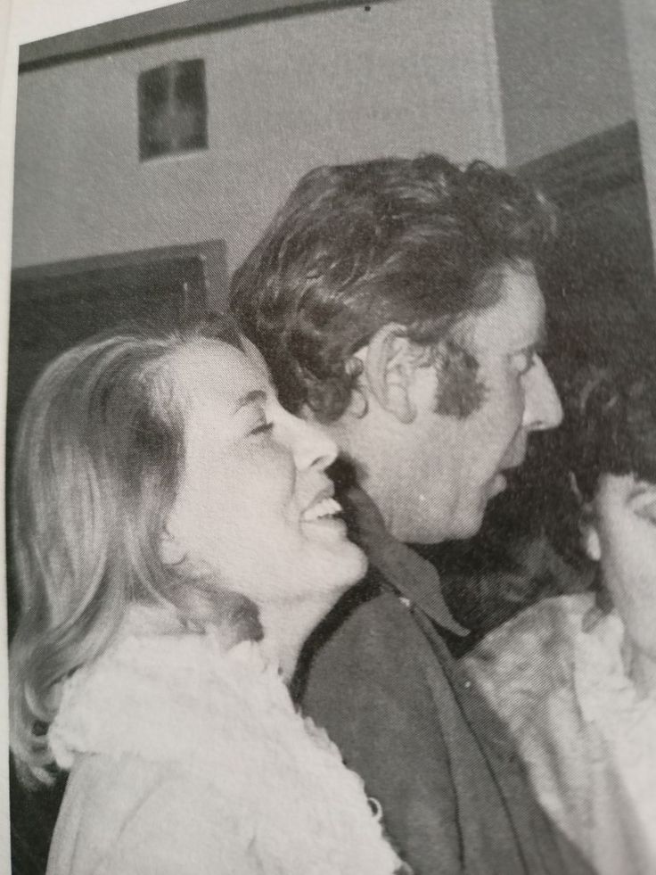 an old black and white photo of two people looking at each other with smiles on their faces