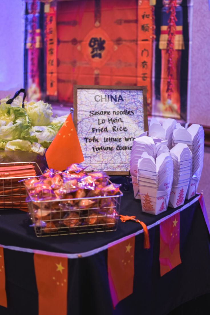 a table topped with lots of food next to a sign that reads china sesame noodles