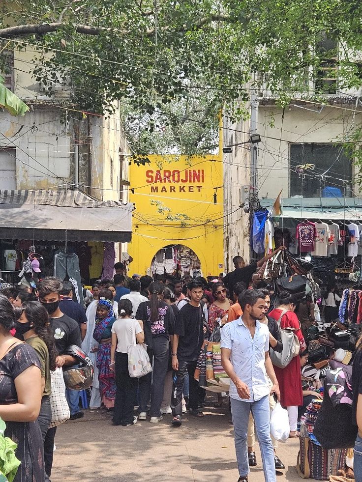 a crowd of people walking around a market