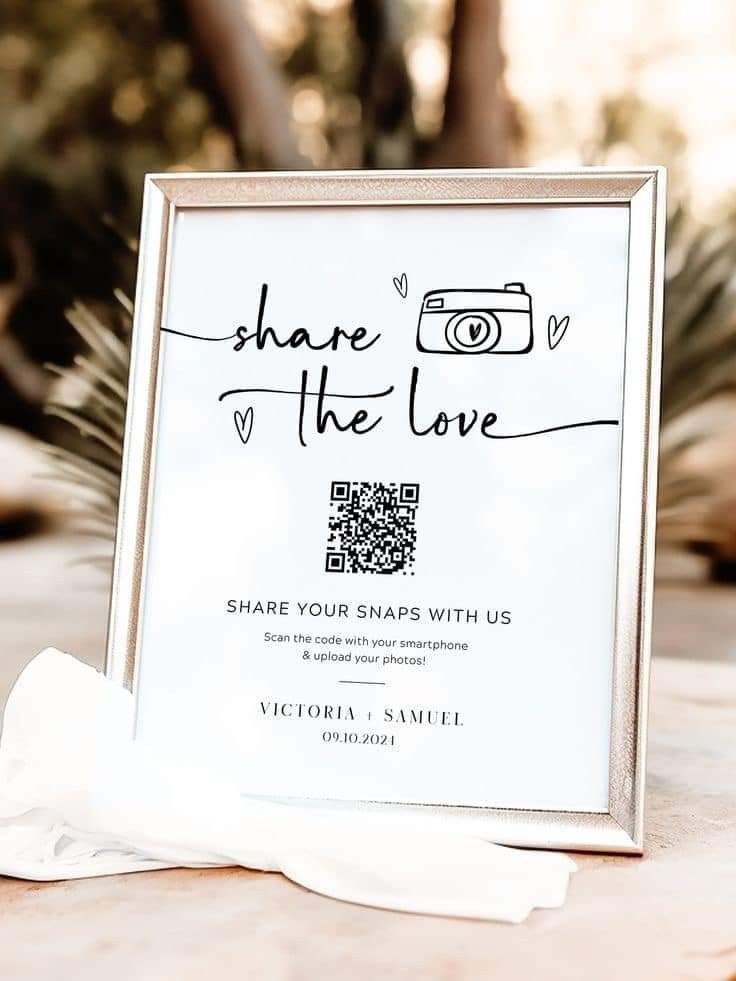 a photo frame sitting on top of a table next to a white napkin and some flowers