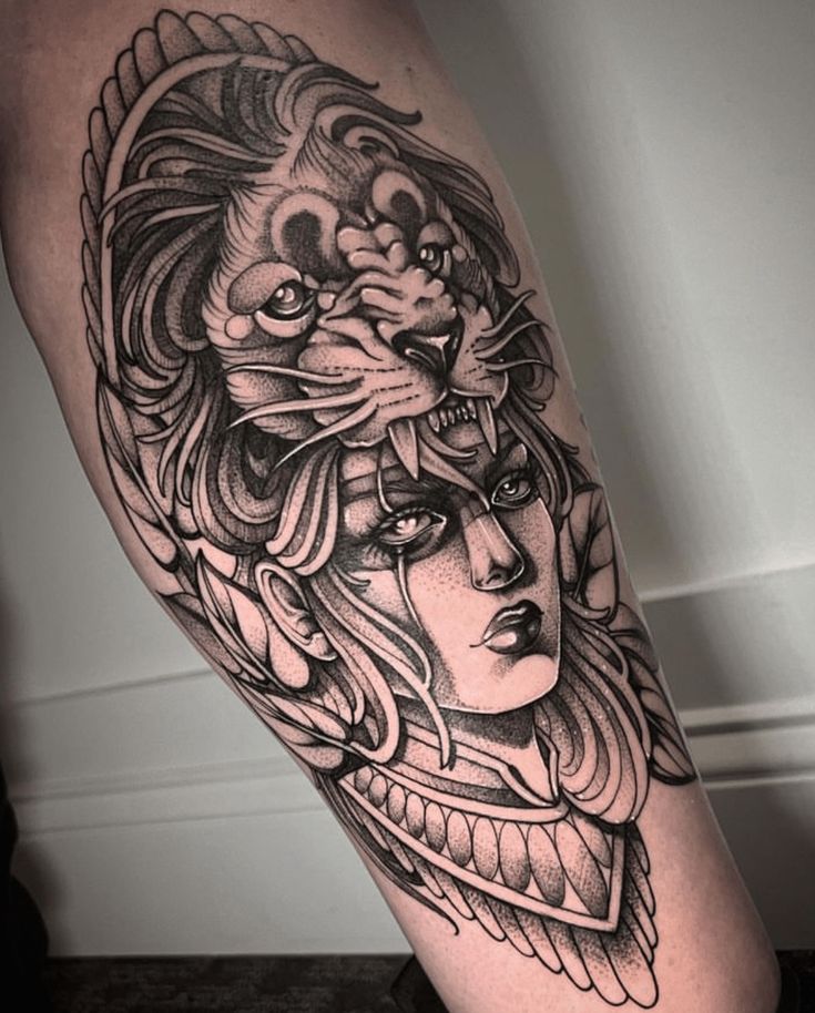 a woman with a lion head tattoo on her leg