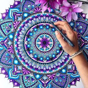 a person drawing on paper with purple flowers