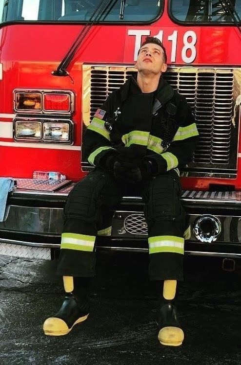 a man sitting on the front of a fire truck