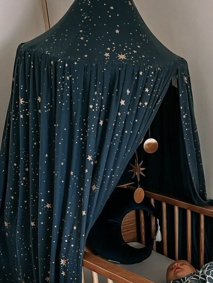 a baby crib with a canopy and stars on it