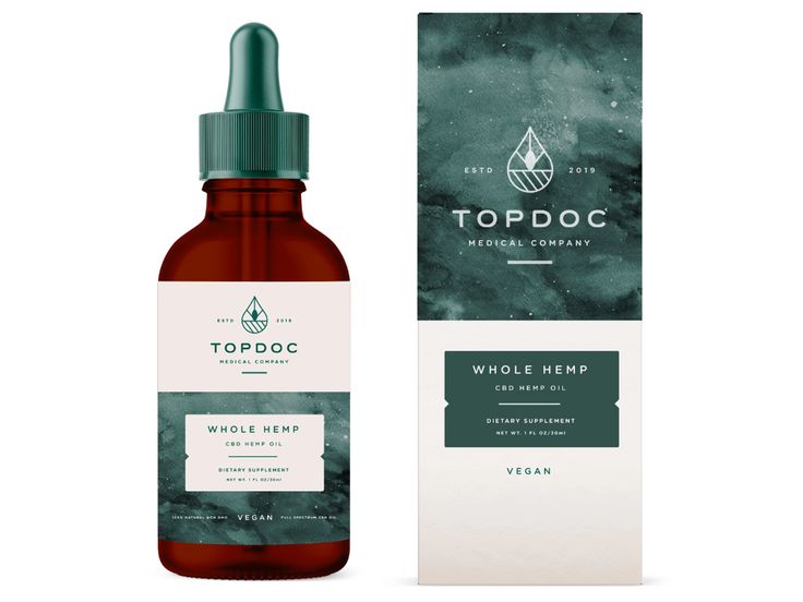 a bottle of top dog whole hemp oil next to a box with the label on it