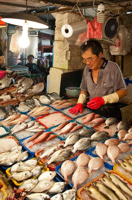 a man standing in front of a table filled with fish