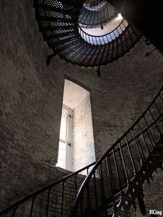 a spiral staircase leading up to an open window