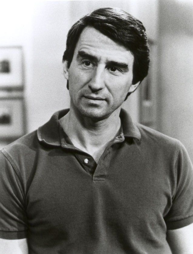 a black and white photo of a man in a polo shirt looking at the camera