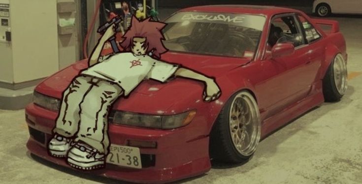 a person sitting on the hood of a red car