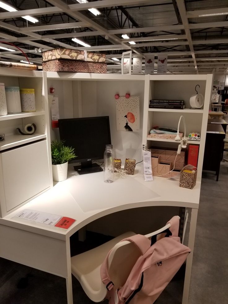 an office desk with a chair and computer monitor on it in a room filled with furniture