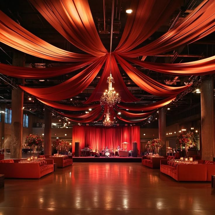 a large room with red drapes on the ceiling and chandeliers hanging from the ceiling