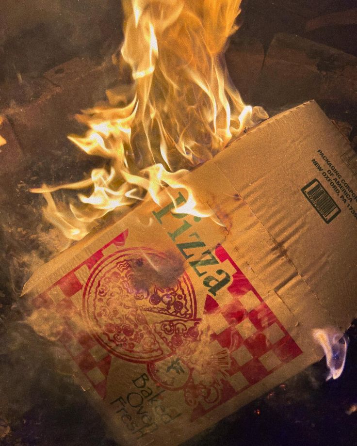 a pizza box is on fire and it looks to be in flames