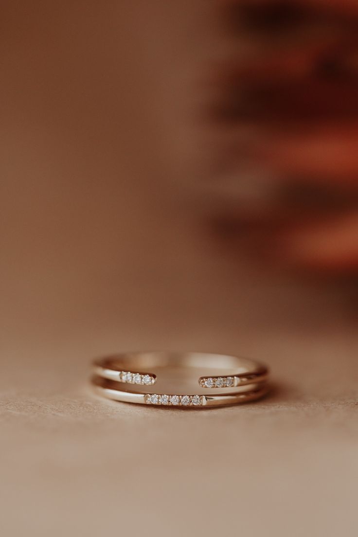 two wedding rings sitting on top of each other