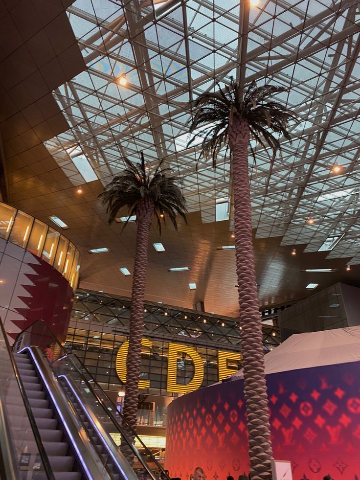 an escalator and palm trees in a large building