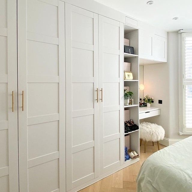 a bedroom with white closets and wooden floors