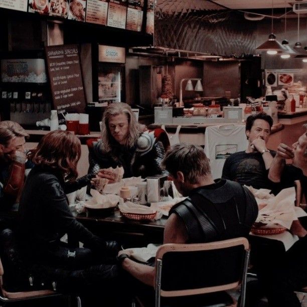 a group of people sitting around a table in a restaurant with food on the plates