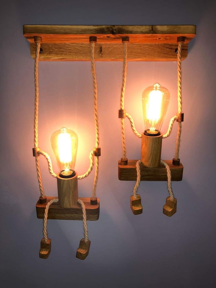 two light bulbs are attached to ropes on the wall